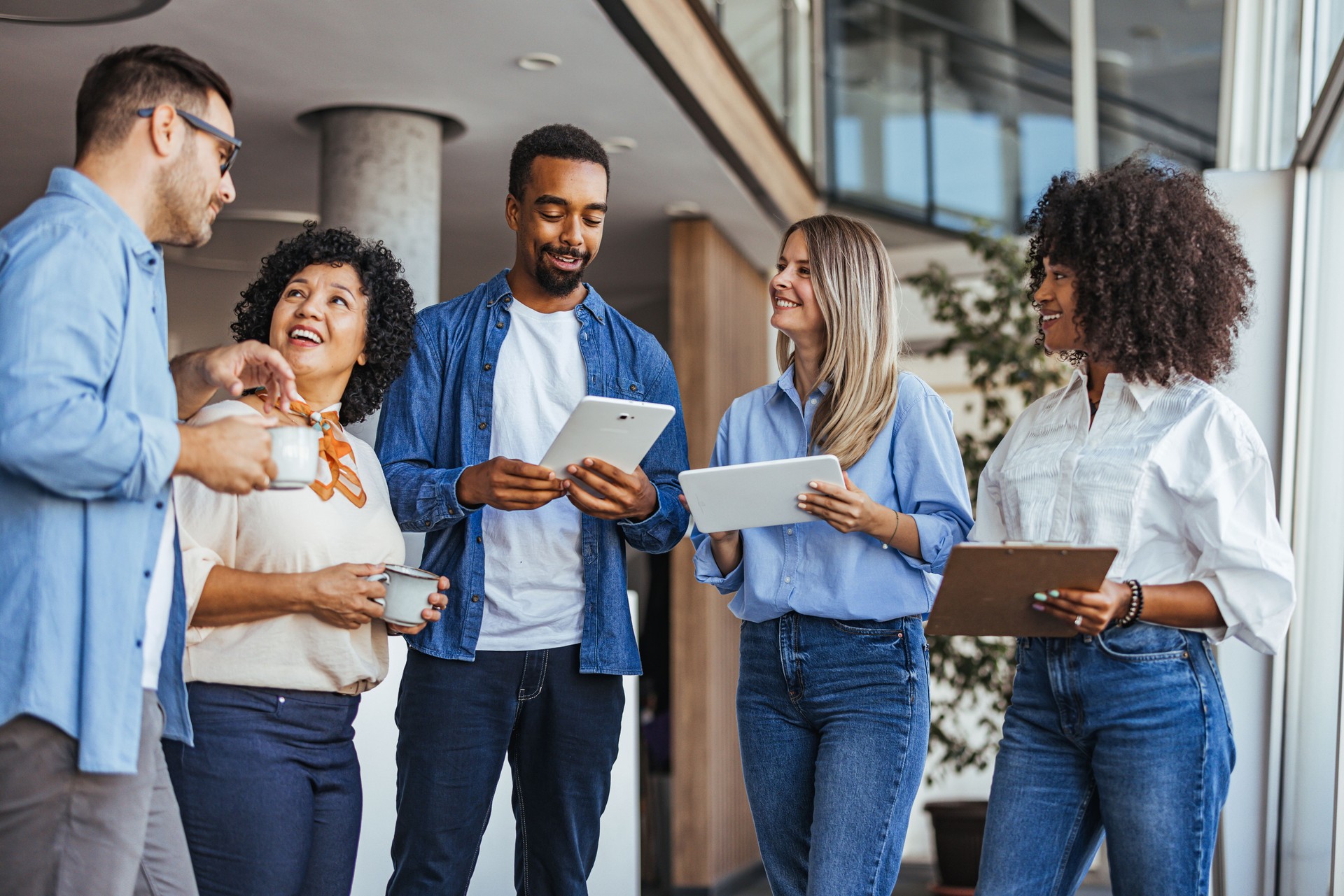 Une équipe diversifiée engagée dans une discussion informelle au bureau avec la technologie