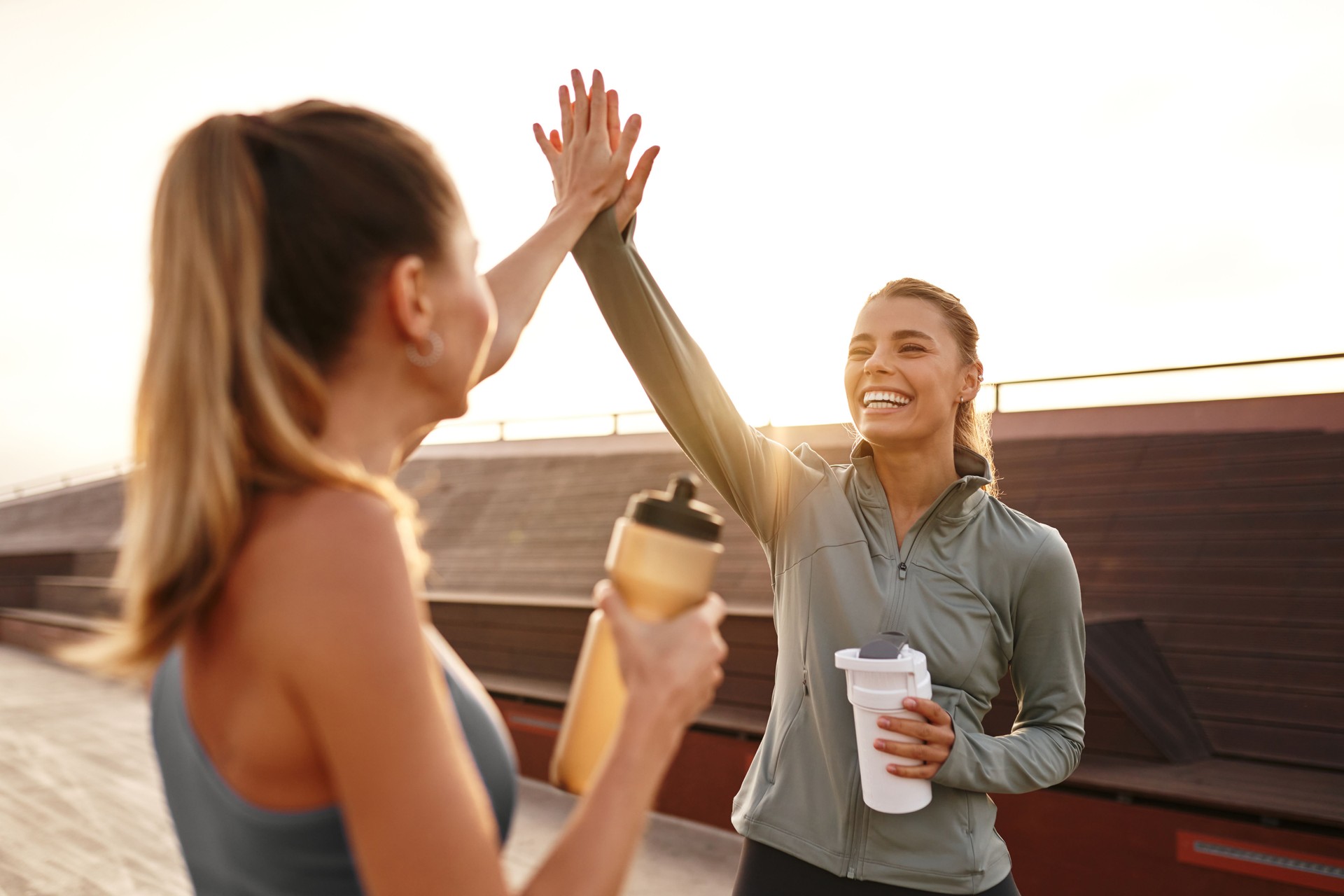 Célébrer les amis du fitness qui partagent des high-fives joyeux après avoir terminé leur séance d’entraînement